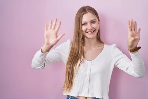 Молодая Белая Женщина Стоящая Розовом Фоне Показывающая Пальцами Номер Девять — стоковое фото