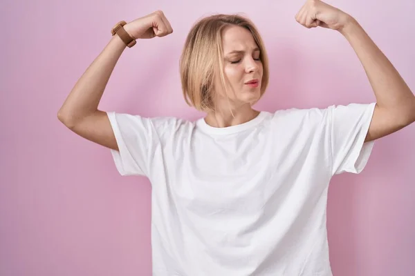 Young Caucasian Woman Standing Pink Background Showing Arms Muscles Smiling — Stok fotoğraf
