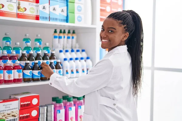 アフリカ系アメリカ人女性薬剤師は自信を持って薬局で棚を整理笑顔 — ストック写真