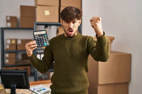 Arab Brodą Pracujący Małym Biznesie Trzymający Kalkulator Zirytowany Sfrustrowany Krzyczący — Zdjęcie stockowe