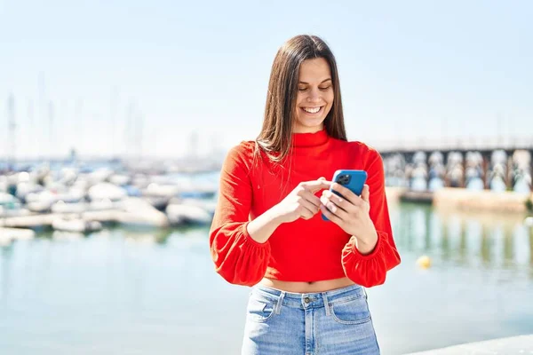 年轻美丽的惊慌失措的女人在海滨用智能手机充满自信地微笑 — 图库照片