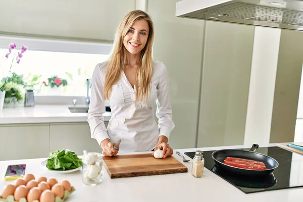 Young Blonde Woman Cooking Beef Cutting Garlic Kitchen — Stock Photo, Image