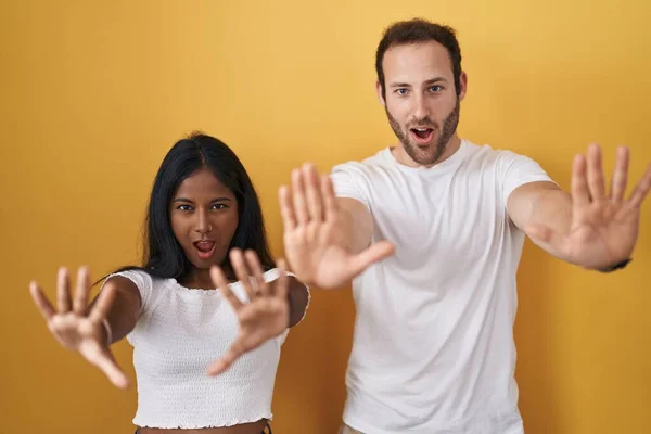 Interracial Couple Standing Yellow Background Doing Stop Gesture Hands Palms — Fotografia de Stock