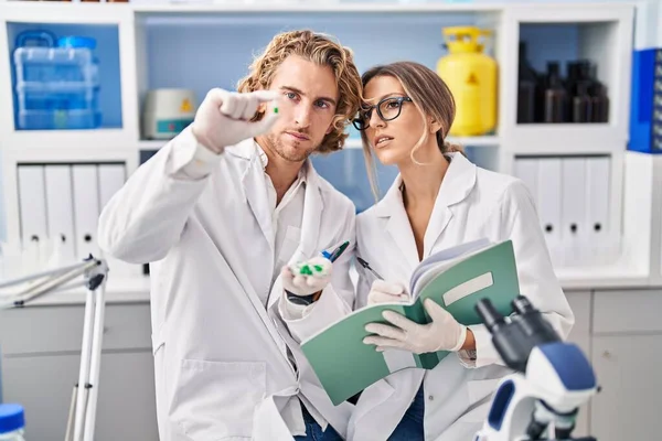Άνδρας Και Γυναίκα Φορώντας Στολή Επιστήμονα Κρατώντας Χάπια Γράφοντας Στο — Φωτογραφία Αρχείου