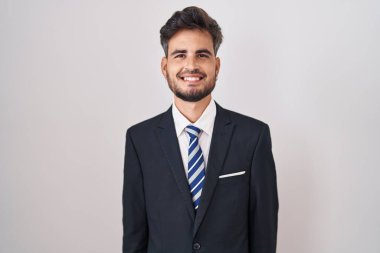 Young hispanic man with tattoos wearing business suit and tie with a happy and cool smile on face. lucky person. 