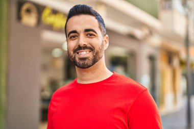 Sokakta kendinden emin gülümseyen İspanyol genç adam.