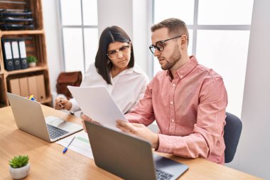 Kadın ve erkek işçiler ofiste çalışıyor.