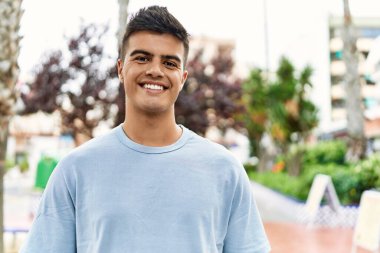 Sokakta kendinden emin gülümseyen İspanyol genç adam.