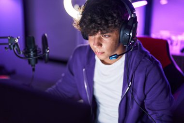 Oyun odasında bilgisayar kullanarak video oyunu oynayan İspanyol asıllı bir genç.