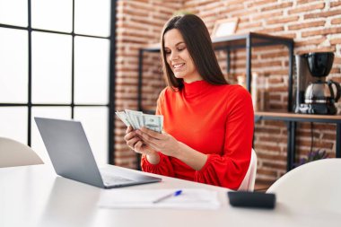 Genç ve güzel İspanyol kadın evde dolar sayıyor.