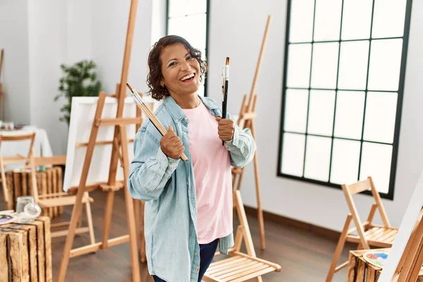 Mujer Artista Hispana Mediana Edad Sonriendo Feliz Sosteniendo Pinceles Estudio —  Fotos de Stock