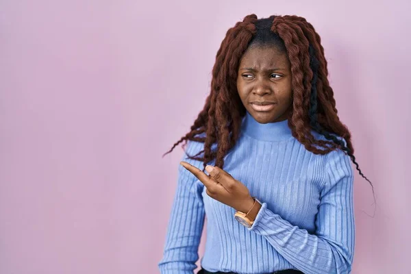 African Woman Standing Pink Background Pointing Aside Worried Nervous Forefinger — Stockfoto