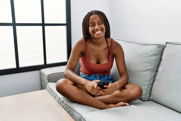 Jovem Afro Americana Usando Smartphone Sentado Sofá Casa — Fotografia de Stock