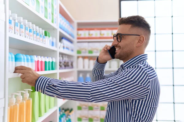 Young Hispanic Man Customer Talking Smartphone Holding Product Shelving Pharmacy — Stok fotoğraf