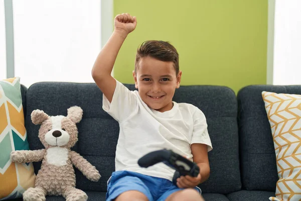 stock image Adorable hispanic toddler playing video game sitting on sofa at home