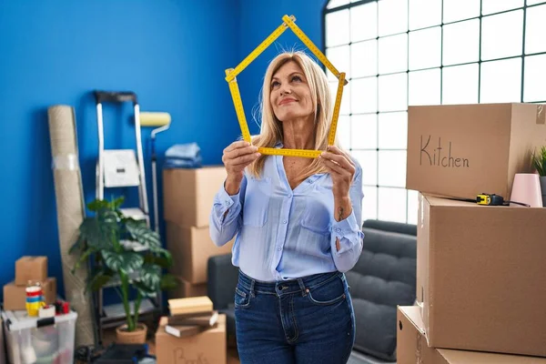 Middle Age Blonde Woman Moving New Home Smiling Looking Side — Stockfoto
