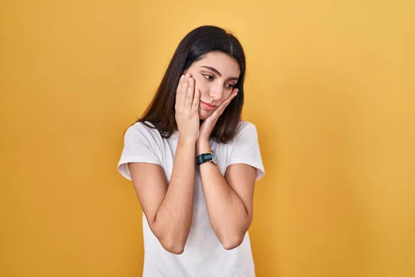 Young Beautiful Woman Standing Yellow Background Tired Hands Covering Face — Foto de Stock