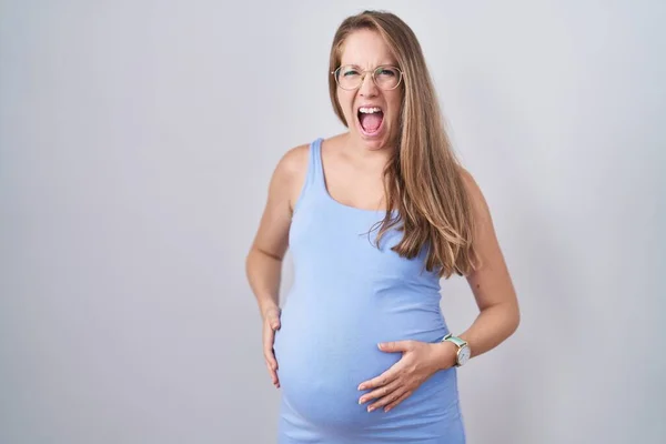 Νεαρή Έγκυος Γυναίκα Στέκεται Πάνω Από Λευκό Φόντο Θυμωμένος Και — Φωτογραφία Αρχείου