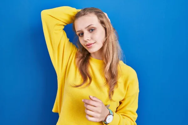 Young Caucasian Woman Standing Blue Background Smiling Confident Touching Hair —  Fotos de Stock