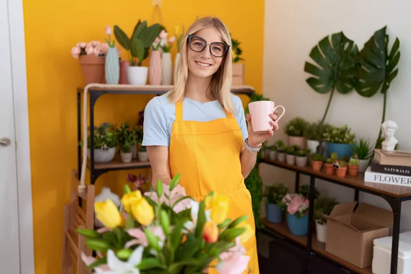 Young Blonde Woman Florist Smiling Confident Drinking Cup Coffee Flower — Stock fotografie