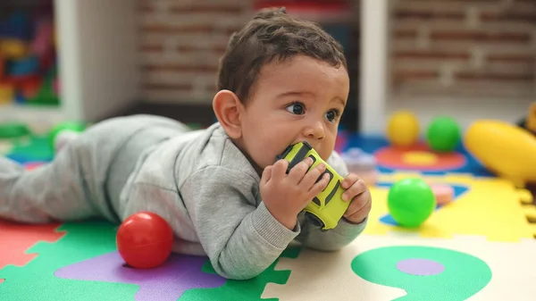 Adorable Bebé Hispano Chupando Juguete Coche Tirado Suelo Jardín Infantes —  Fotos de Stock