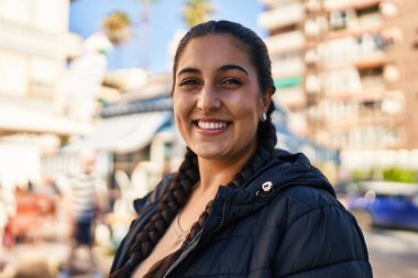 Sokakta kendine gülen genç İspanyol kadın.