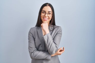 İspanyol iş kadını gözlüklü, kameraya kendinden emin bakıyor kolları çapraz ve çenesi havada gülümsüyor. Olumlu düşünmek. 