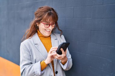 Middle age woman business executive make selfie by the smartphone at street