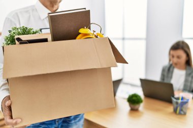 Orta yaşlı erkek ve kadın işçiler çalışanı kovuyor.