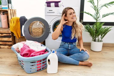 Çamaşır sepetinin yanında oturan genç ve güzel bir kadın kulağına fısıldayarak dedikoduları ve dedikoduları dinliyor. Sağırlık kavramı. 