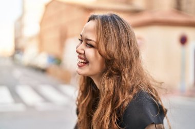 Young beautiful hispanic woman smiling confident looking to the side at street
