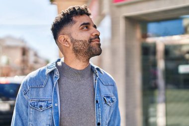 Sokakta kendinden emin gülümseyen İspanyol genç adam.