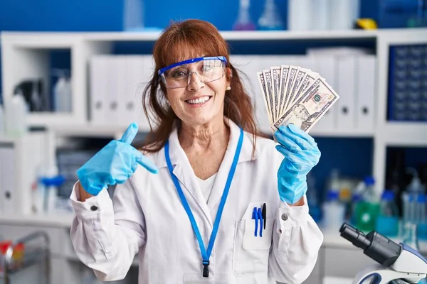 中年ヒスパニック女性仕事で科学者研究所保持ドル指差す指に1つの自己笑顔幸せと誇り — ストック写真
