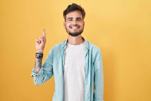 Joven Hombre Hispano Con Tatuajes Pie Sobre Fondo Amarillo Mostrando —  Fotos de Stock