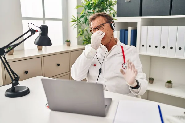 Senior Doctor Man Working Online Appointment Smelling Something Stinky Disgusting — Stock fotografie