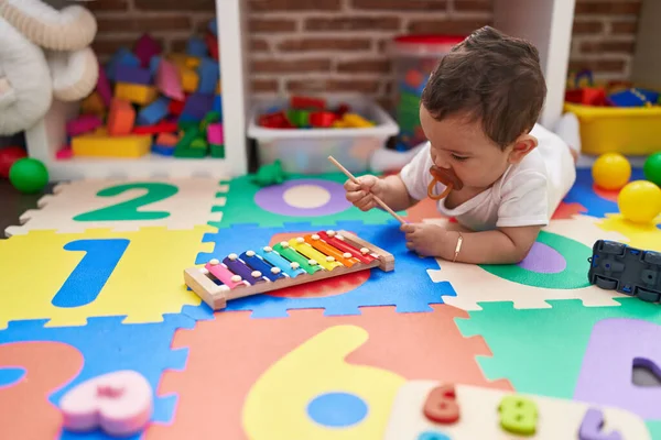 在幼儿园的地板上玩木琴的惊慌失措的宝宝非常可爱 — 图库照片