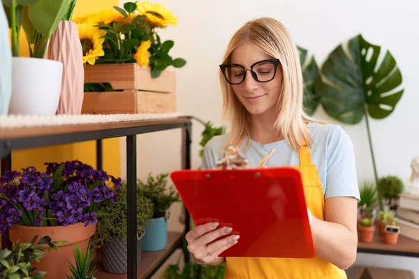 Young Blonde Woman Florist Smiling Confident Writing Document Flower Shop — Stockfoto