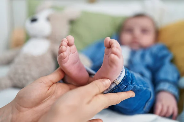 Adorable Caucasian Baby Lying Bed Mother Hands Holding Feet Bedroom — Stock Photo, Image