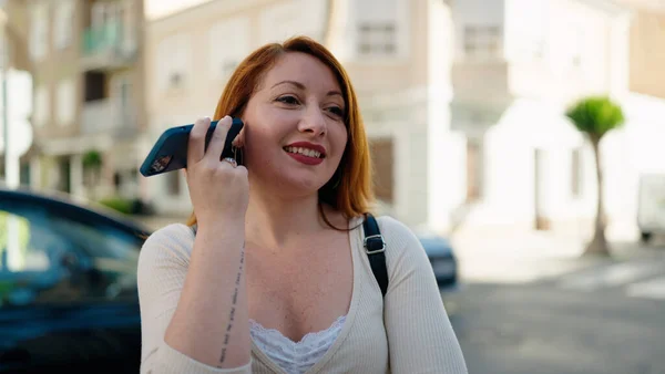 Молодая Рыжая Женщина Улыбается Уверенно Слушая Аудиосообщение Смартфона Улице — стоковое фото