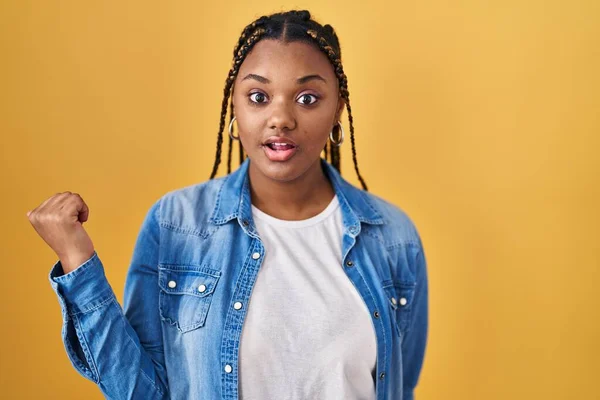 African American Woman Braids Standing Yellow Background Surprised Pointing Finger — ストック写真