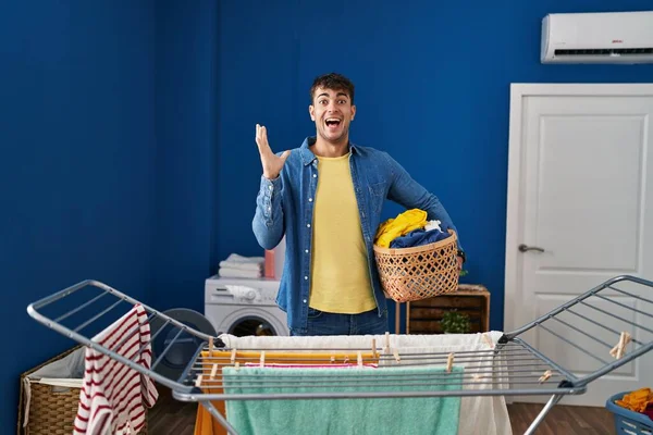 Young Hispanic Man Hanging Clothes Clothesline Celebrating Victory Happy Smile — Stockfoto