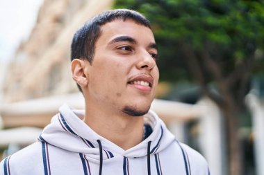 Sokakta kendine güvenen genç adam gülümsüyor