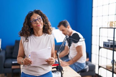Orta yaşlı İspanyol bir kadın müzik stüdyosunda şarkı söylüyor. Gülümsüyor, yan tarafa bakıyor ve düşünüyor.. 