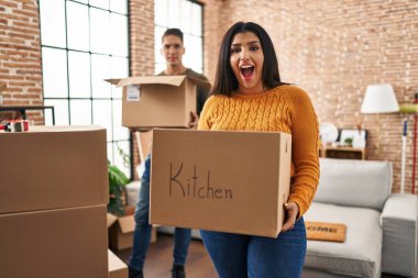 Karton kutularla dolu yeni bir eve taşınan genç çift şaşkınlık ve şaşkınlık dolu bir ifade, korku ve heyecan dolu bir yüz ifadesiyle şok oldu.. 