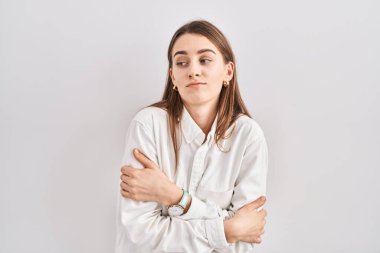 Kafkasyalı genç bir kadın izole edilmiş arka planda duruyor. Kış soğuğu yüzünden titriyor ve donuyor. Yüzünde üzgün ve şok ifadesi var. 