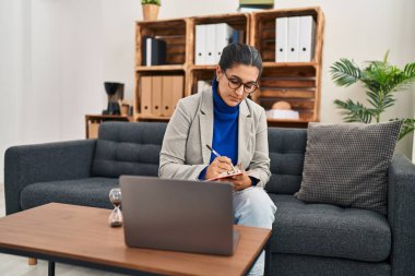 Young hispanic woman having online psychology session at clinic