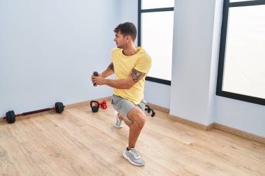 Genç İspanyol adam spor merkezinde ağırlık çalışması yapıyor.