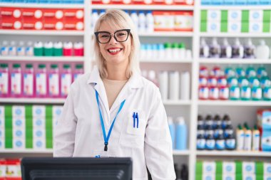 Young caucasian woman working at pharmacy drugstore with a happy and cool smile on face. lucky person. 