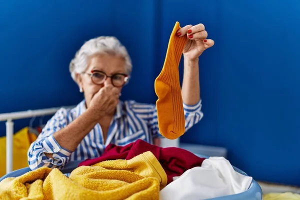 Starší Šedovlasá Žena Páchnoucí Špinavou Ponožkou Prádelně — Stock fotografie