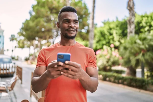 Nuori Afrikkalainen Amerikkalainen Mies Hymyilee Luottavainen Käyttämällä Älypuhelin Puistossa — kuvapankkivalokuva